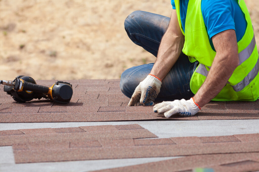 roofing contractor in corsicana, texas laying down new asphalt shingles