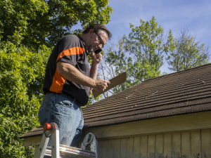 Skilled roofer in Canton inspecting a roof for exceptional craftsmanship.